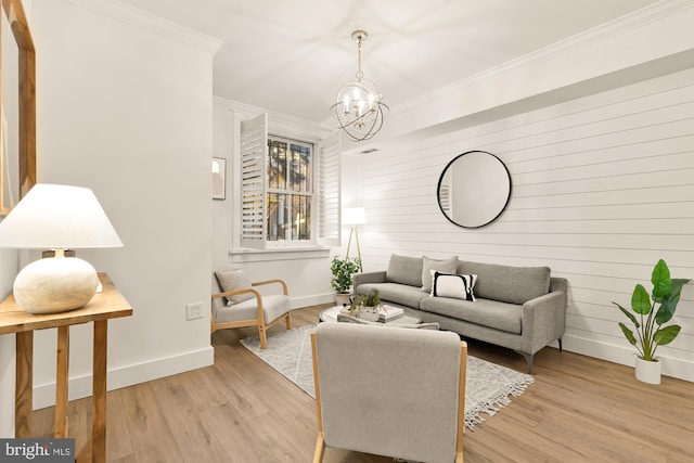 living area with baseboards, light wood-style floors, and ornamental molding