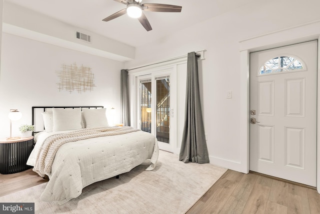 bedroom featuring visible vents, multiple windows, wood finished floors, and access to outside