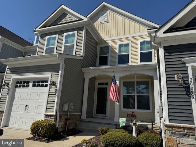 view of front of home with stone siding, board and batten siding, and an attached garage