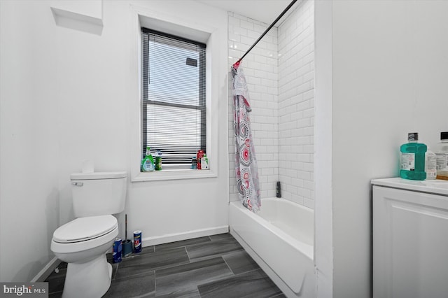 bathroom with shower / bath combo with shower curtain, toilet, baseboards, and wood finish floors