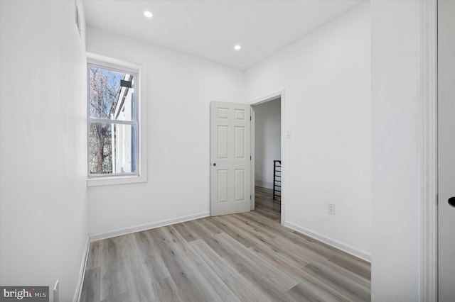 spare room with recessed lighting, baseboards, and light wood finished floors