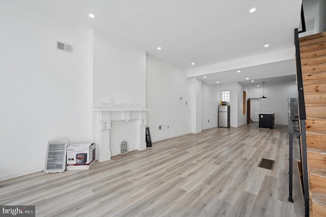 unfurnished living room featuring light wood finished floors, visible vents, and recessed lighting