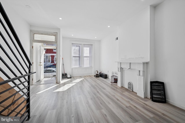 unfurnished living room with recessed lighting, light wood-style flooring, visible vents, and baseboards