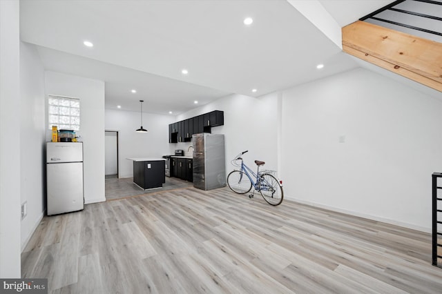 interior space with light countertops, recessed lighting, freestanding refrigerator, light wood-style floors, and dark cabinets