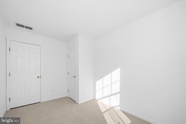 spare room featuring visible vents, baseboards, and carpet