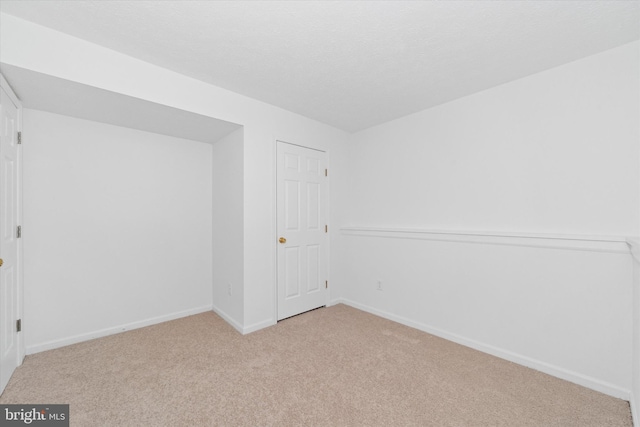 empty room featuring baseboards and carpet flooring