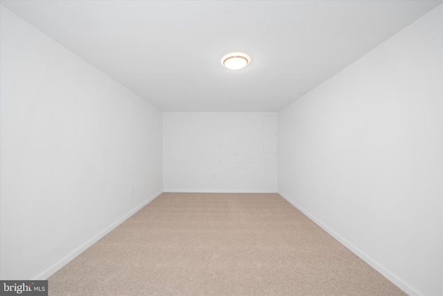 empty room featuring light colored carpet and baseboards