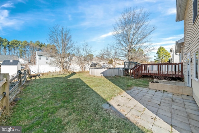 view of yard featuring a patio area, a fenced backyard, and a wooden deck