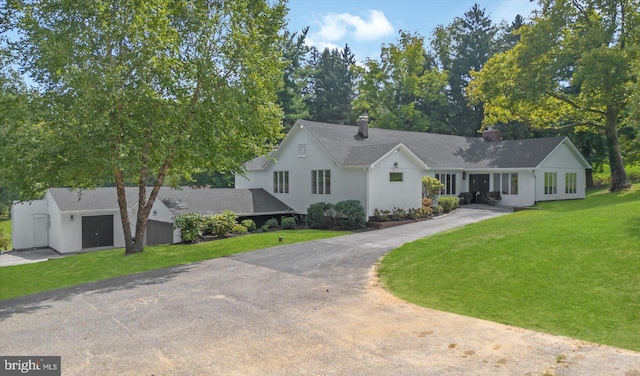 view of front facade with aphalt driveway and a front yard