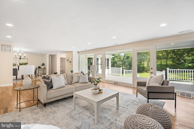 living area featuring an inviting chandelier, recessed lighting, light wood-style floors, and visible vents