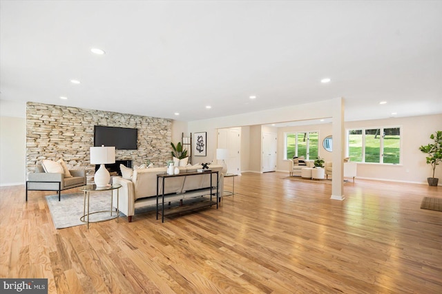 living room featuring recessed lighting, baseboards, and light wood-style flooring