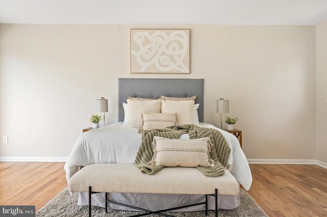 bedroom with baseboards and wood finished floors