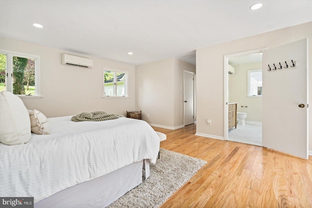 bedroom with a wall mounted air conditioner, multiple windows, recessed lighting, and light wood finished floors