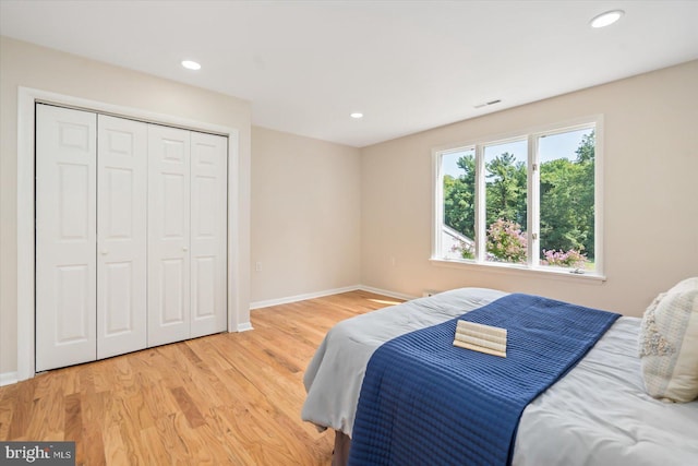 bedroom with visible vents, baseboards, recessed lighting, light wood-style flooring, and a closet