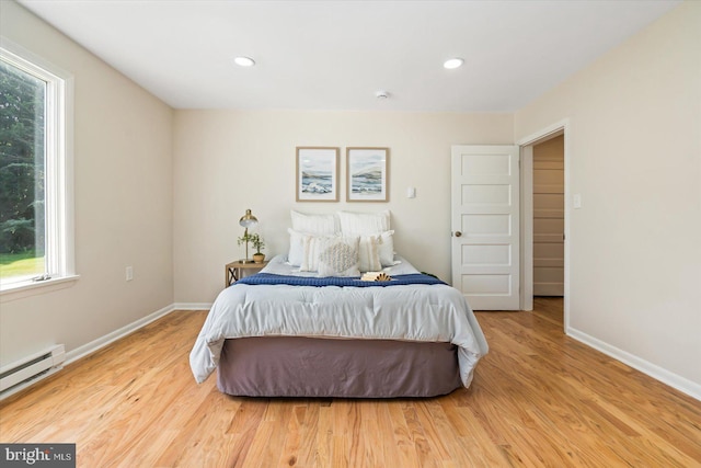 bedroom featuring recessed lighting, baseboards, baseboard heating, and wood finished floors