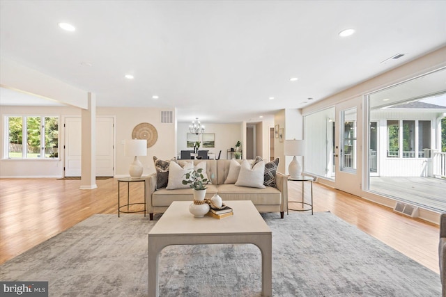 living room featuring recessed lighting, visible vents, and light wood-style flooring