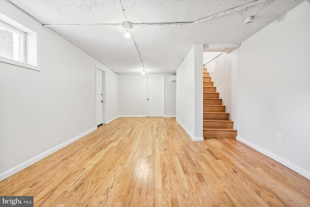 basement with stairway, wood finished floors, and baseboards