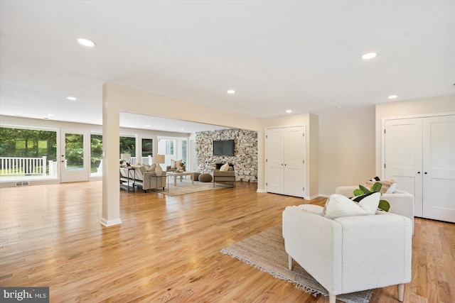 living area with recessed lighting, baseboards, light wood-style floors, and a fireplace