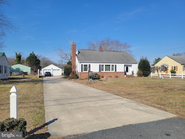 view of front facade with an outbuilding, fence, a front lawn, a garage, and brick siding