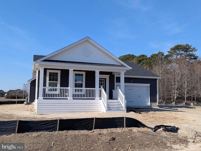 view of front facade featuring covered porch, a garage, and roof with shingles