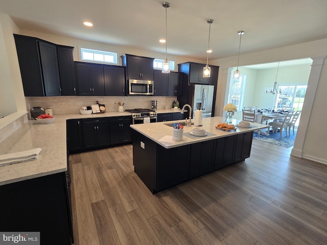 32912 Tern Cv, Long Neck, DE 19966 - kitchen featuring tasteful backsplash, dark cabinetry, stainless steel appliances, a sink, and wood finished floors