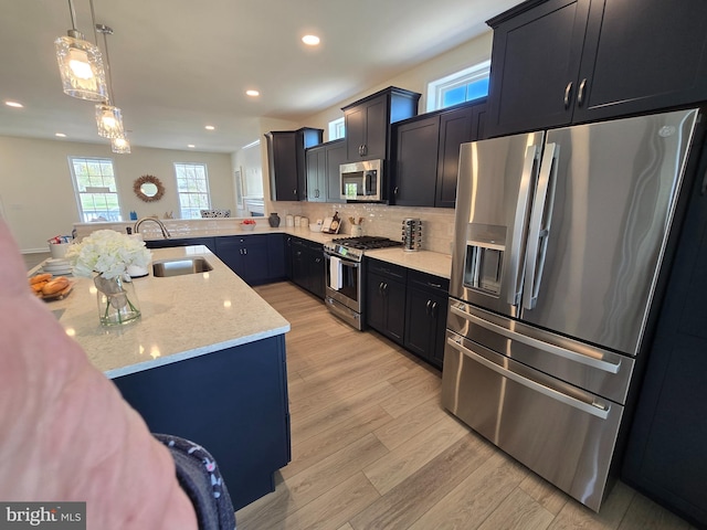 32912 Tern Cv, Long Neck, DE 19966 - kitchen featuring tasteful backsplash, light wood-type flooring, light stone counters, appliances with stainless steel finishes, and a sink