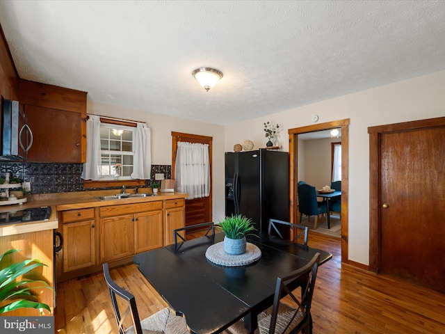 dining space with light wood finished floors and a textured ceiling