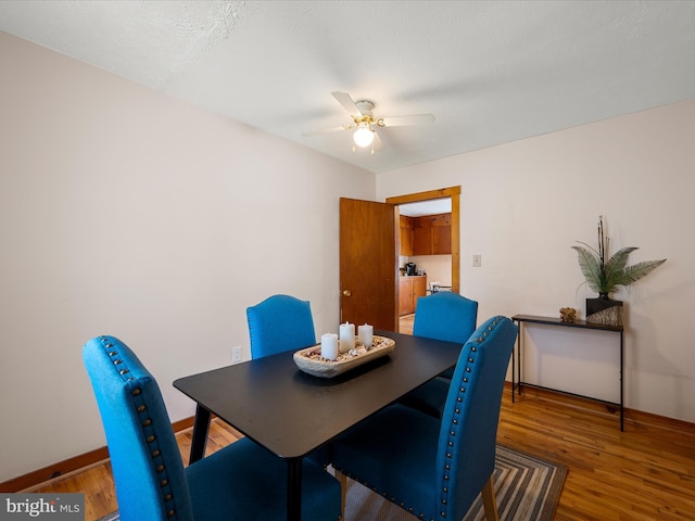 dining area with ceiling fan, baseboards, and wood finished floors