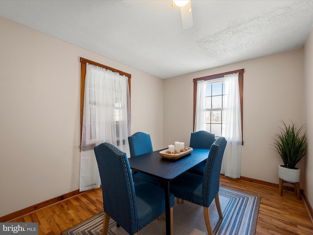 dining area featuring wood finished floors, baseboards, and a textured ceiling