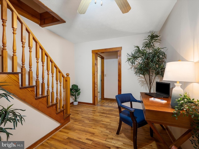 home office featuring baseboards, light wood-type flooring, and a ceiling fan