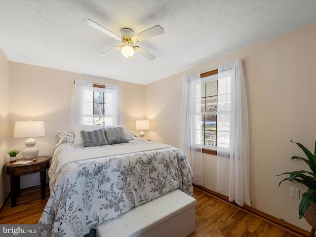 bedroom featuring ceiling fan, a textured ceiling, and wood finished floors