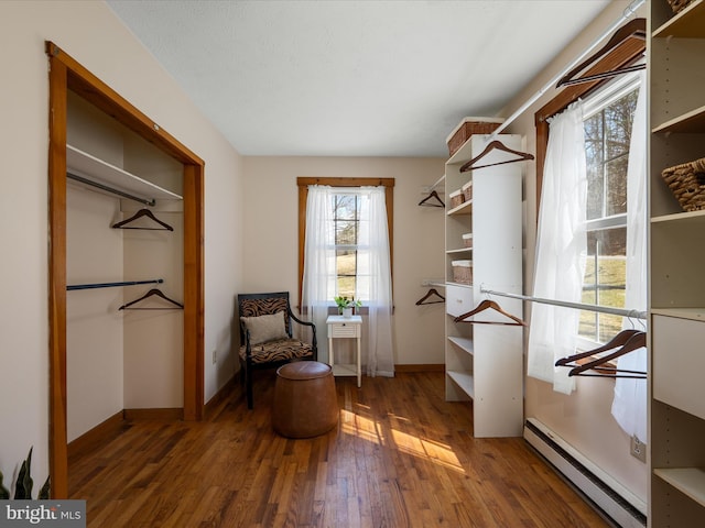 living area with wood finished floors, baseboards, and a baseboard radiator