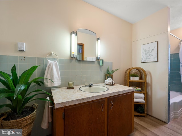 full bathroom with vanity, shower / bath combination with curtain, wood finished floors, and tasteful backsplash