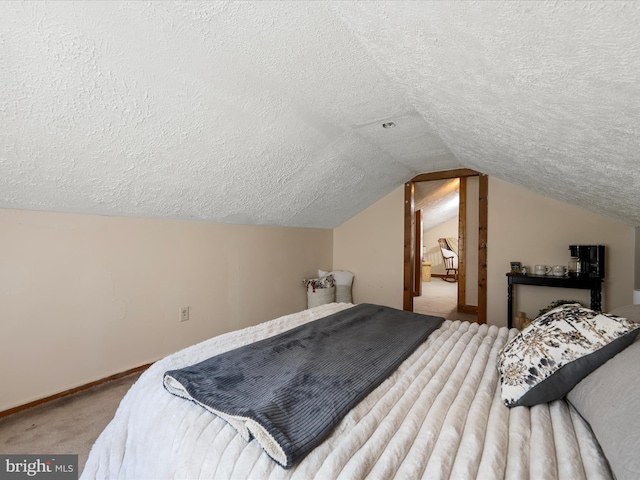 bedroom with baseboards, carpet floors, a textured ceiling, and lofted ceiling