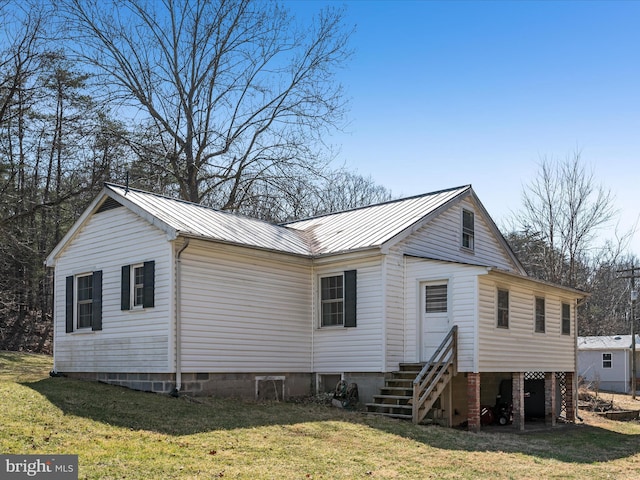 exterior space with metal roof, a lawn, and entry steps