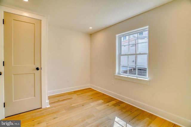 empty room with recessed lighting, light wood-style floors, and baseboards