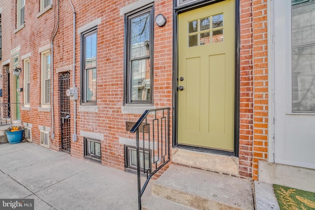 view of exterior entry with brick siding