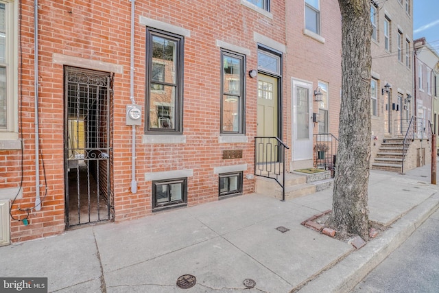 view of exterior entry featuring brick siding