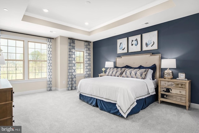 bedroom featuring baseboards, a tray ceiling, carpet floors, and visible vents