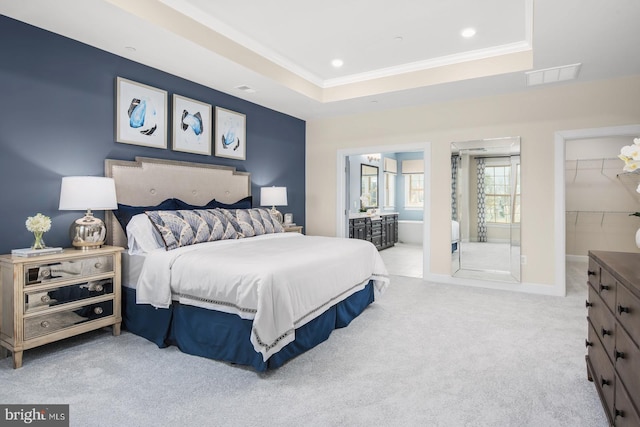 carpeted bedroom featuring visible vents, ornamental molding, a tray ceiling, baseboards, and a spacious closet