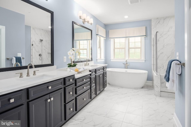 bathroom featuring a shower with shower door, plenty of natural light, marble finish floor, and a sink