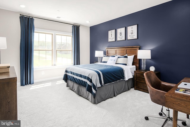 bedroom with visible vents, light colored carpet, and baseboards