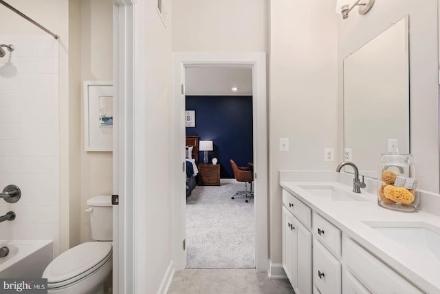 ensuite bathroom featuring double vanity, toilet, ensuite bathroom, and a sink