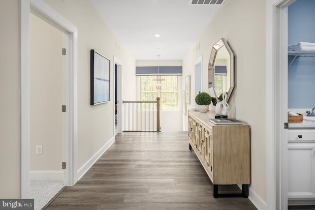 hallway featuring dark wood finished floors, visible vents, recessed lighting, and baseboards