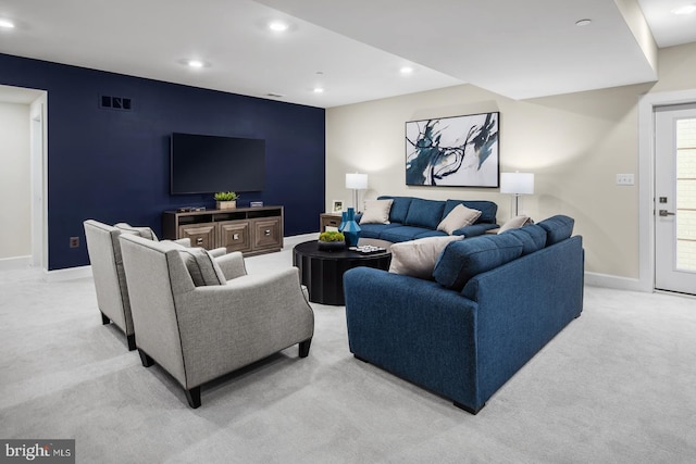 living room featuring visible vents, an accent wall, baseboards, light colored carpet, and recessed lighting