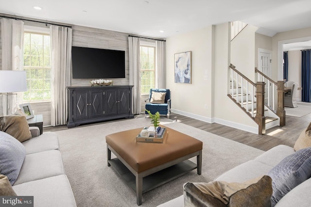 living room with recessed lighting, baseboards, wood finished floors, and stairs