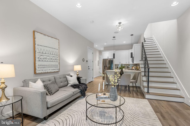 living area with recessed lighting, stairs, light wood-type flooring, and baseboards