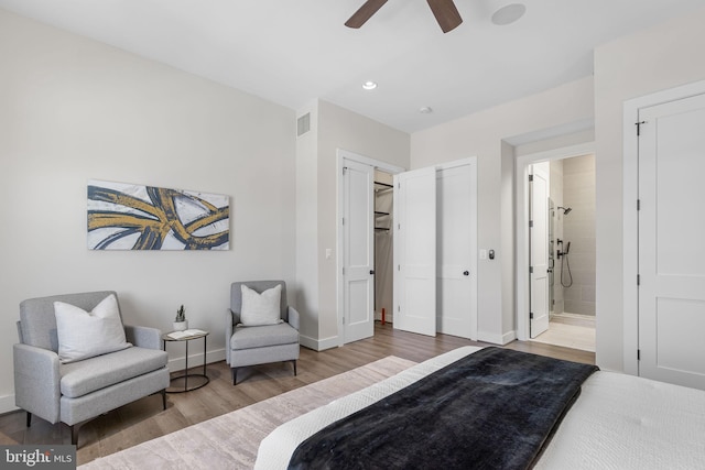 bedroom featuring visible vents, ensuite bath, wood finished floors, recessed lighting, and baseboards