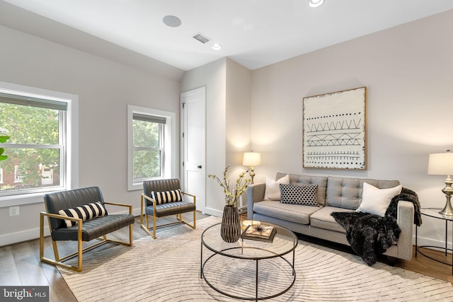 living area with visible vents, recessed lighting, baseboards, and wood finished floors