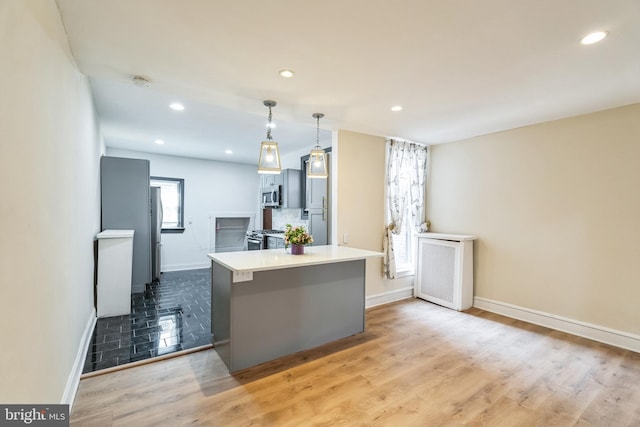 kitchen with recessed lighting, appliances with stainless steel finishes, pendant lighting, and light wood finished floors